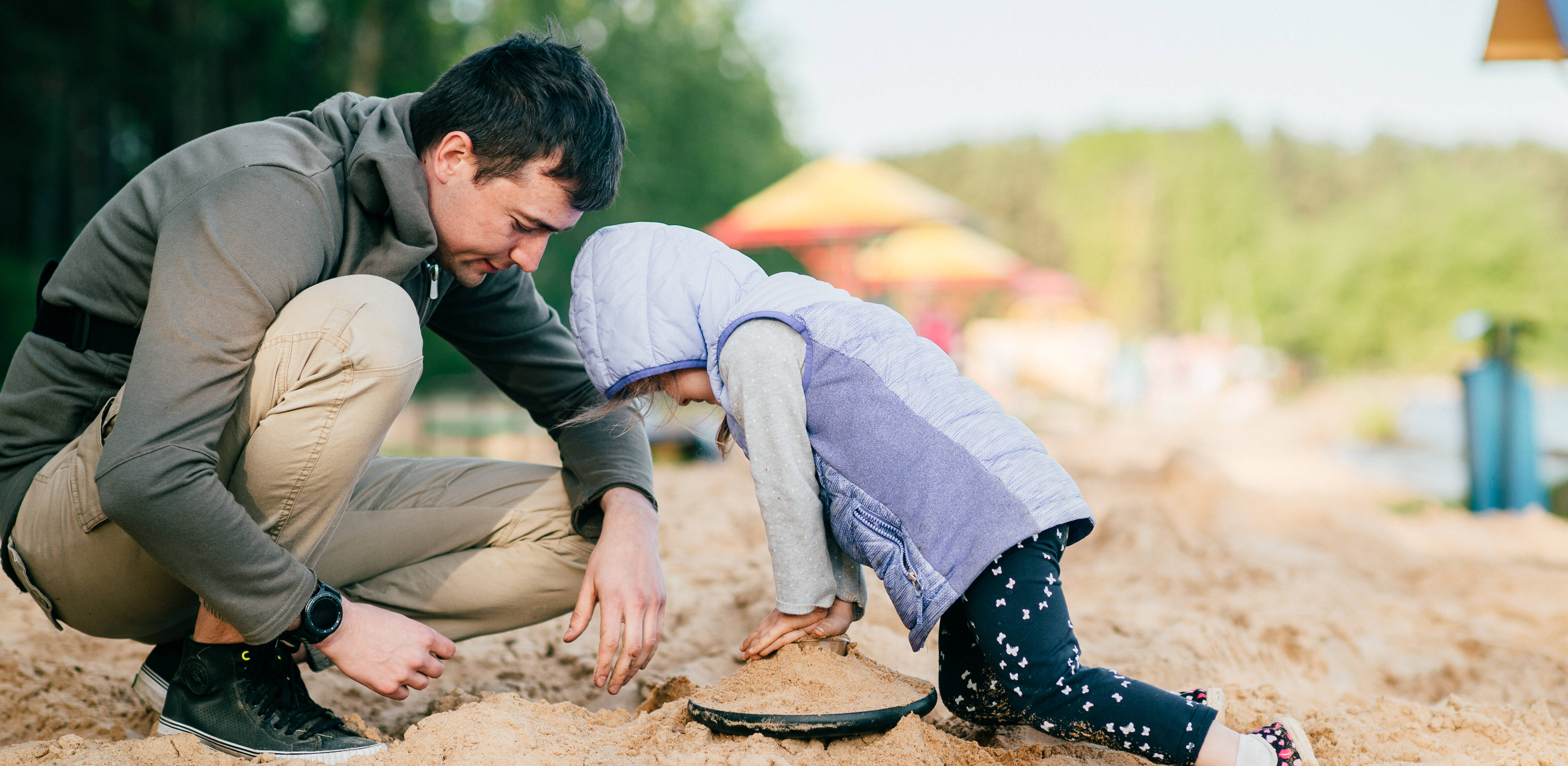 Vater und Kind spielen im Sand - Fachkräfte helfen psychisch und suchterkrankten Eltern